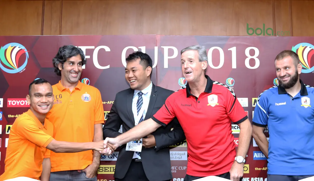 Pelatih Tampines Rovers, Juergen Raab (2kanan) bersalaman Riko Simanjuntak saat konferensi pers Piala AFC 2018  di Hotel Sultan, Jakarta (27/2/2018). Persija melawan Tampines Rovers pada 28 Februari 2018. (Bola.com/Nick Hanoatubun)