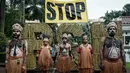 Greenpeace Indonesia mengatakan ambisi Presiden Prabowo bisa membabat jutaan hutan alam dan mengabaikan keberadaan masyarakat adat Papua. Tampak dalam foto, aktivis Greenpeace Indonesia dan bersama beberapa pemuda Papua menggelar aksi teatrikal saat berunjuk rasa di depan Kantor Kementerian Koordinator bidang Perekonomian, Jakarta, Kamis (18/12/2025). (Yasuyoshi Chiba/AFP)