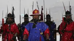 Penjaga istana mengenakan seragam militer tradisional berdiri selama hujan salju di Istana Gyeongbok di Seoul, Korea Selatan (13/12). Istana Gyeongbok aslinya didirikan tahun 1394 oleh Jeong do jeon, seorang arsitek.  (AP Photo/Ahn Young-joon)