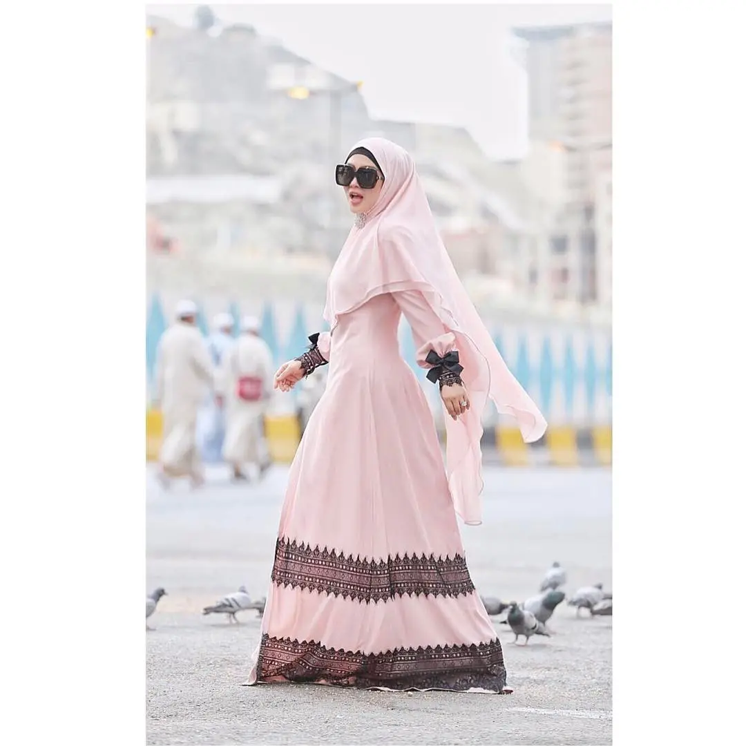 Gamis pink pastel yang diberi detail pita pada bagian tangannya bikin penampilan Syahrini trendi . (sumber foto: @princessyahrini/instagram)
