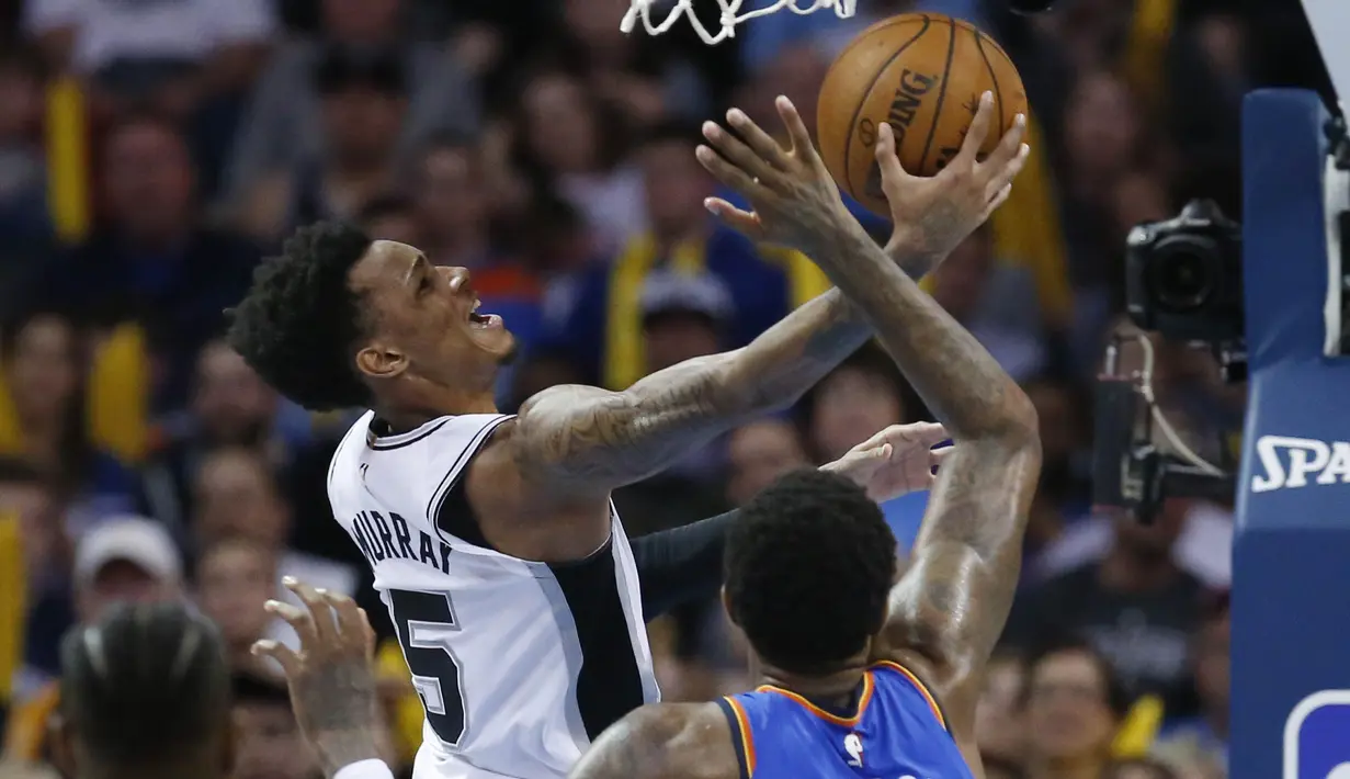 Pebasket San Antonio Spurs, Dejounte Murray, berusaha memasukan bola saat pertandingan melawan Oklahoma City Thunder pada laga NBA di Chesapeake Energy Arena, Minggu (11/3/2018). Thunder menang 104-94 atas Spurs. (AP/Sue Ogrocki)