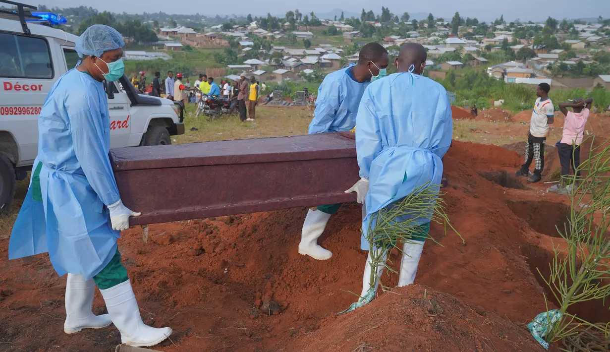 Petugas yang mengenakan pakaian pelindung menurunkan peti mati seorang anak berusia enam tahun yang meninggal akibat Ebola saat pemakaman di Bunia, Provinsi Ituri, Kongo timur, Selasa, 18 Agustus 2026. (Foto AP/Dieudonne Dirole)