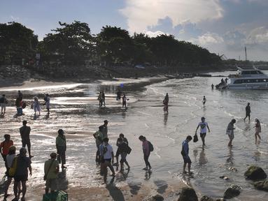 Wisatawan antre naik ke kapal boat menuju kawasan wisata Nusa penida dan Nusa lembongan di Pelabuhan Sanur, Denpasar, Bali, Senin (2/5/20222). Libur panjang lebaran tahun ini berdampak positif kepada jumlah keberangkatan wisatawan menuju Nusa Penida ataupun Nusa Lembongan. (merdeka.com/Arie Basuki)