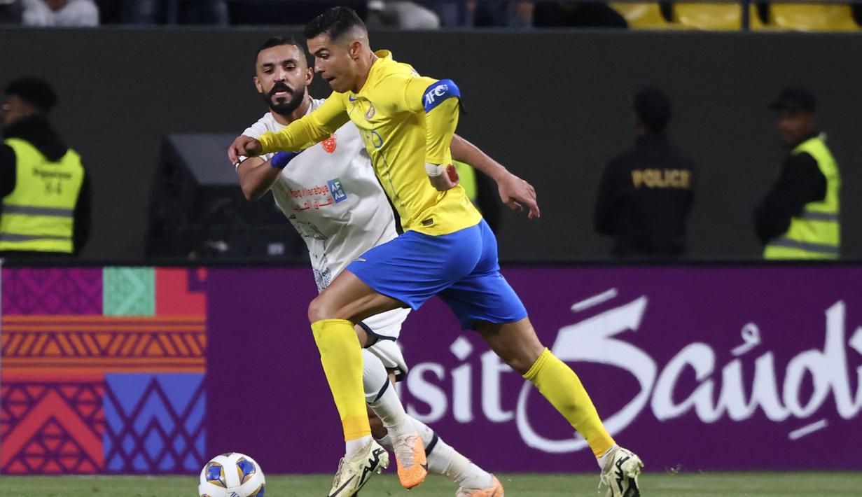 <p>Pemain Al-Nassr, Cristiano Ronaldo berusaha melewati pemain Al-Fieha, Hussein al-Shuwaish saat laga 16 besar Liga Champions Asia 2023/2024 di Al-Awwal Park Stadium, Riyadh, Arab Saudi Rabu (21/02/2024) waktu setempat. (AFP/Fayez Nureldine)</p>