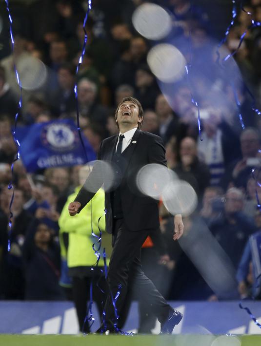 Antonio Conte  berjalan serta menatap pita biru yang berjatuhan saat perayaan kemenangan lusai melawan Watford pada laga Premier League di Stamford Bridge stadium, London, (15/5/2017). Chelsea menang 4-3. (AP/Tim Ireland)