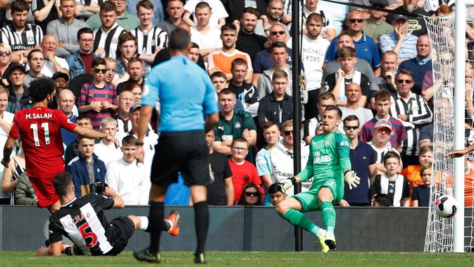 Penyerang Liverpool Mohamed Salah (kiri) mencetak gol ke gawang Newcastle United pada laga Liga Inggris di Anfield, Liverpool, Inggris, Sabtu (14/9/2019). Mohamed Salah dan Sadio Mane membawa Liverpool menghajar Newcastle 3-1. (AP Photo/Rui Vieira)