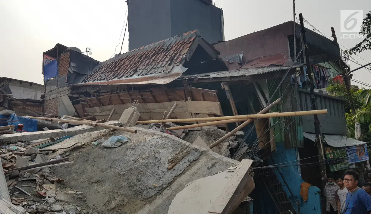 Sejumlah warga melihat rumah roboh di  Jalan Pulo, Tanah Tinggi, Johar Baru, Jakarta Pusa, Jumat (26/4). Hingga saat ini petugas masih melakukan evakuasi warga yang masih terjebak di dalam puing bangunan rumah yang ambruk. (Liputan6.com/Herman Zakharia)