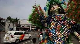 Pengunjung melintasi karya instalasi dari limbah minuman kemasan yang menghiasi Jl.Malioboro, Yogyakarta, (5/6).Pameran seni rupa ruang publik di pajang bertujuan  untuk memperindah kawasan Malioboro yang ramai di kunjungi pejalan kaki.(Boy Harjanto)