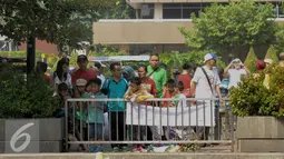 Sejumlah warga mengajak keluarganya menyambangi lokasi ledakan di Kawasan Thamrin, Jakarta, Minggu (17/1/2016). Pasca Ledakan Thamrin, kegiatan Car Free Day tetap ramai seperti biasa. (Liputan6.com/Faisal R Syam)