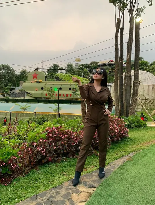 Tampil menawan dengan seragam berwarna coklat army, wanita yang akrab disapa Depe ini juga tak melupakan kacamata mewahnya. Ia pun memadukan kacamata hitam yang digunakan dengan sepatunya. 
(Liputan6.com/IG/@dewiperssikreal.new)