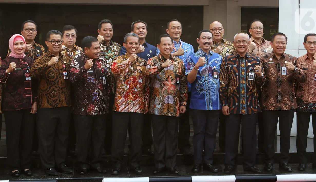 Menteri Dalam Negeri Tito Karnavian (tengah) foto bersama dengan para staf usai apel seluruh Pegawai Lingkup Kemendagri dan BNPP di halaman kantor Kemendagri, Jakarta, Kamis (24/10/2019). Dalam apel perdana ini Tito memberikan arahan kepada semua pegawai Kemendagri. (Liputan6.com/Johan Tallo)
