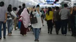 Seorang warga berselfie sebelum mencoba menaiki moda raya Terpadu  Mass Rapid Transit  MRT di Stasiun MRT Bundaran HI, Jakarta, Jumat (29/3). Terkait tarif kereta MRT minimum yag telah disepakati adalah Rp.3000 sampai maksimum Rp.14.000 dari Lebak Bulus- Bundaran HI. (merdeka.com/Imam Buhori)