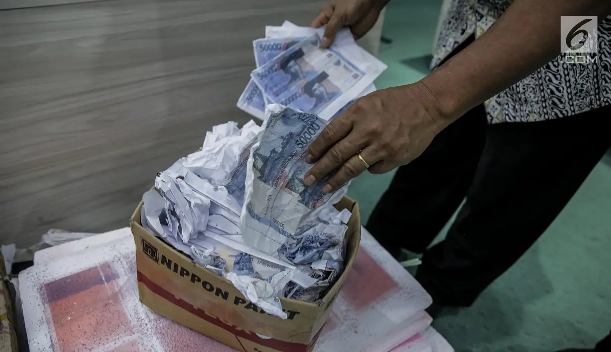 Petugas Direktorat Tindak Pidana Ekonomi Khusus Bareskrim Polri memperlihatkan uang palsu saat rilis di Bareskrim Polri, Jakarta, Jumat (16/6). Dalam penangkapan polisi mengamankan 1.000 lembar uang pecahan Rp 50.000 palsu. (Liputan6.com/Faizal Fanani)
