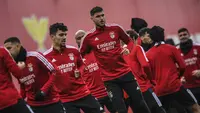 Penyerang Benfica, Roman Yaremchuk (tengah) dan rekan satu timnya melakukan pemanasan selama sesi latihan di tempat latihan Kampus Benfica di Seixal dekat Lisbon (14/3/2022). Benfica akan bertanding melawan Ajax pada leg kedua babak 16 besar Liga Champions di Amsterdam Arena. (AFP/Patricia De Melo M