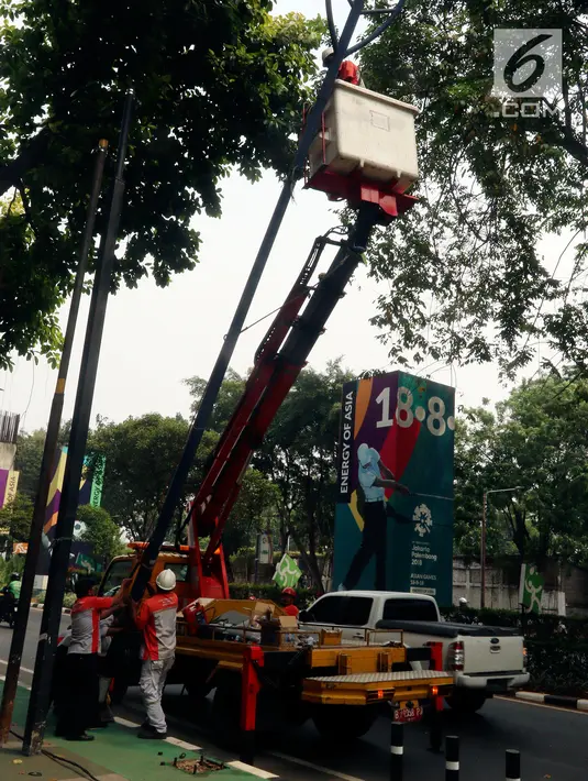 Petugas Suku Dinas PE Jakarta Pusat bersama Satgas PJU mencabut lampu penerangan jalan yang menghalangi jalur sepeda di trotoar Jalan Asia Afrika dan Jalan Gelora, Senayan, Jakarta, Rabu (1/8). (Liputan6.com/Johan Tallo)