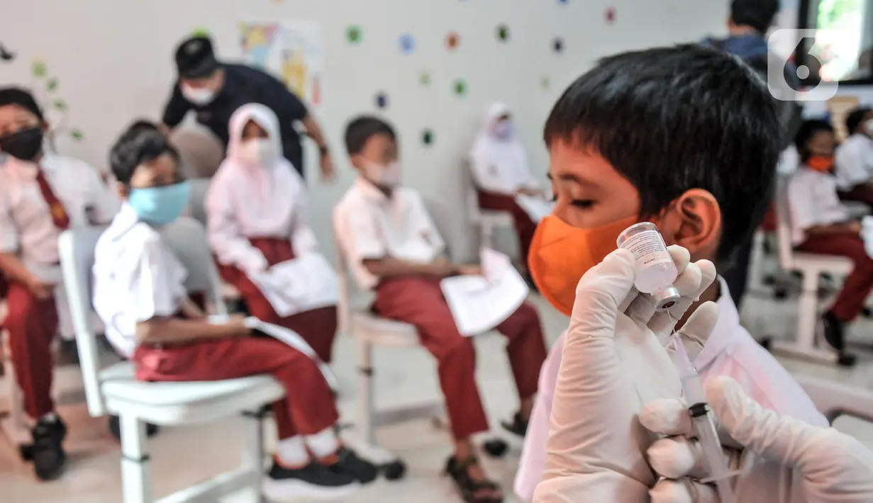 Petugas kesehatan menyiapkan vaksin COVID-19 saat akan menyuntik seorang murid di SDN Cempaka Putih Timur 03 Pagi, Jakarta, Selasa (14/12/2021). Pemerintah mulai melakukan vaksinasi COVID-19 kepada anak usia 6-11 tahun. (merdeka.com/Iqbal S. Nugroho)