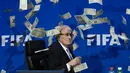 Simon Brodkin melemparkan segepok uang dollar sebagai bentuk protes atas korupsi yang terjadi di tubuh FIFA sebelum dimulainya konferensi pers di kantor FIFA di Zurich., Swiss. (20/7/2015). (AFP PHOTO/FABRICE COFFRINI)