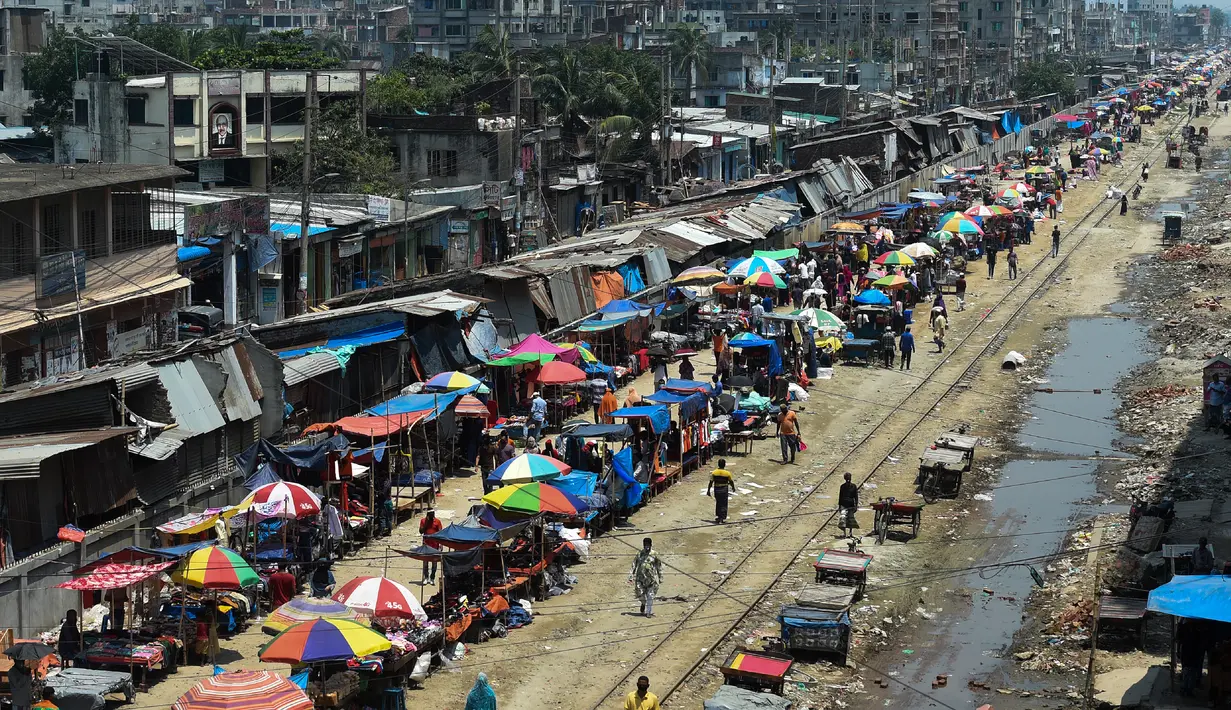 Warga memadati jalan yang dipenuhi lapak pedagang di area pasar tradisional selama karantina wilayah masih diberlakukan pemerintah setempat di Dhaka, Bangladesh (12/5/2020). (AFP/Munir Uz Zaman)