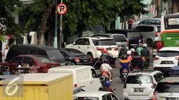 Sejumlah kendaraan terparkir di bawah tanda larangan di badan Jalan Kramat Raya, Jakarta, Senin (8/8). Rencananya, semua lokasi parkir on street akan dipasangi mesin terminal parkir elektronik (TPE). (Liputan6.com/Helmi Fithriansyah)