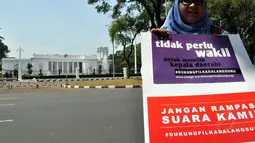 Puluhan aktivis Koalisi Kawal RUU Pilkada membentangkan sebuah poster berukuran 5x3 bertuliskan surat terbuka untuk Presiden SBY, Jakarta, (16/8/14). (Liputan6.com/Miftahul Hayat)