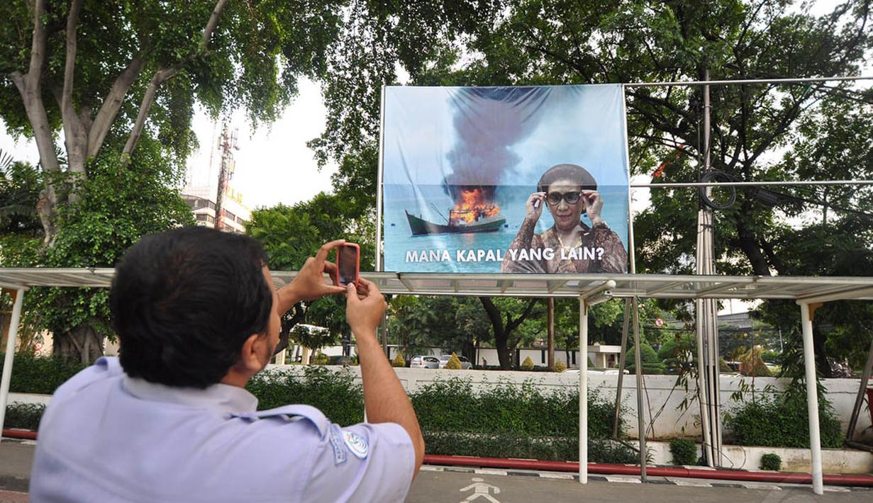 Menteri Susi Pudjiastuti memasang poster di halaman kantor KKP, Jakarta. Foto diambil pada Kamis (11/12/2014). (Liputan6.com/Miftahul Hayat)