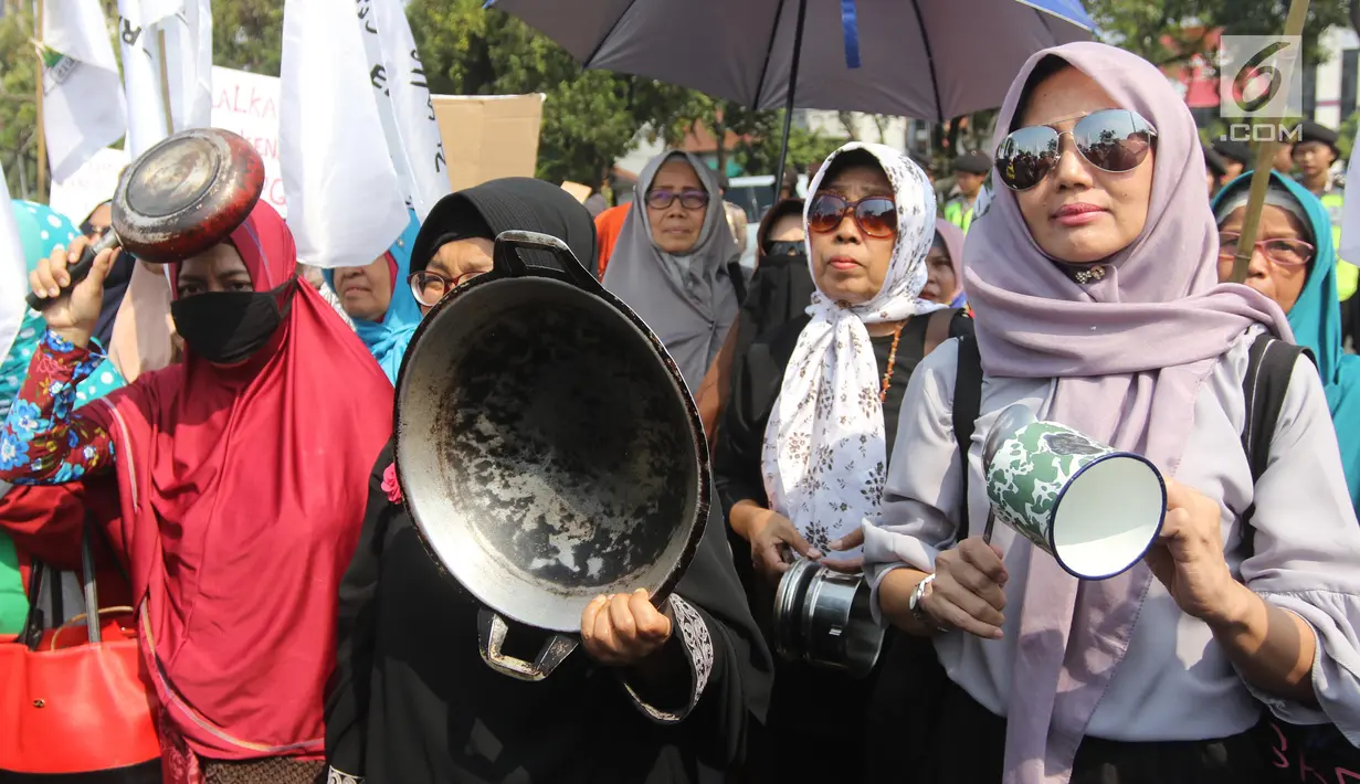 Sejumlah ibu-ibu yang tergabung dalam Barisan Emak-Emak Militan (BE2M) Indonesia menggelar aksi di seberang Istana Merdeka, Jakarta, Rabu (18/7). Mereka menuntut Presiden Jokowi menurunkan harga sembilan bahan pokok (sembako). (Liputan6.com/Arya Manggala)