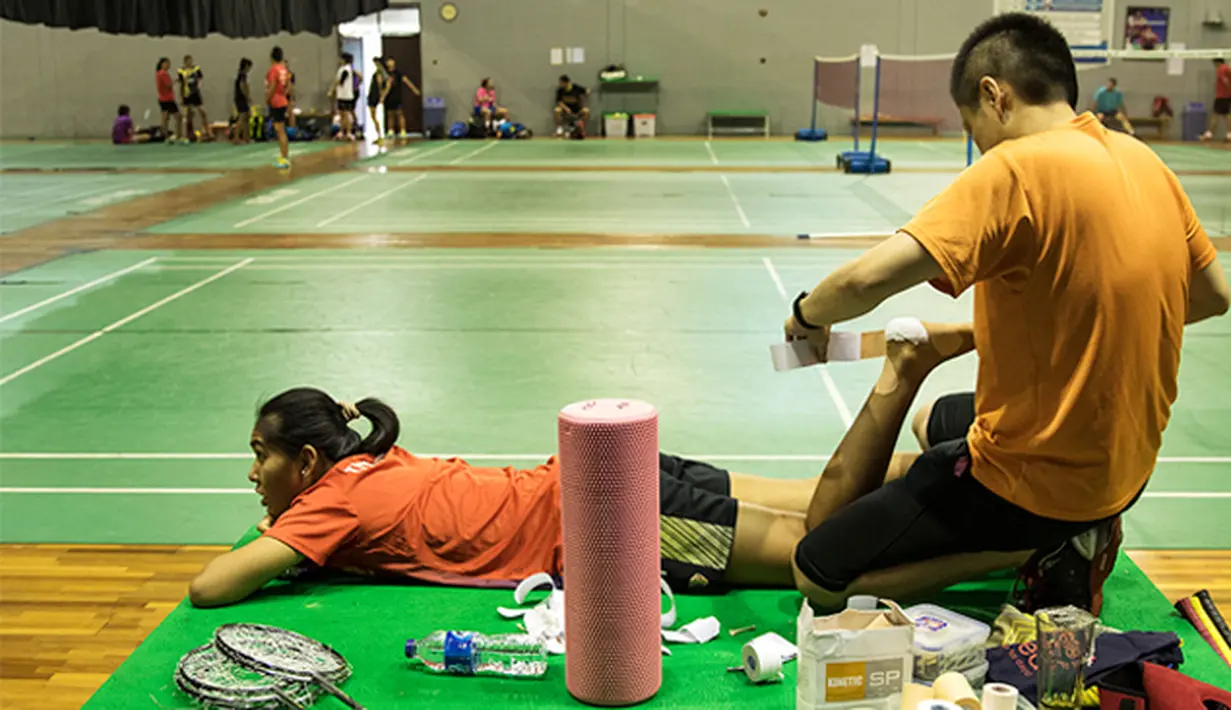 Nitya Krishinda Maheswari dipasangi perban pada kakinya sebelum berlatih jelang Kejuaraan Dunia BWF 2015 di Pelatnas Cipayung, Jakarta, Selasa (4/8/2015). (Bola.com/Vitalis Yogi Trisna)