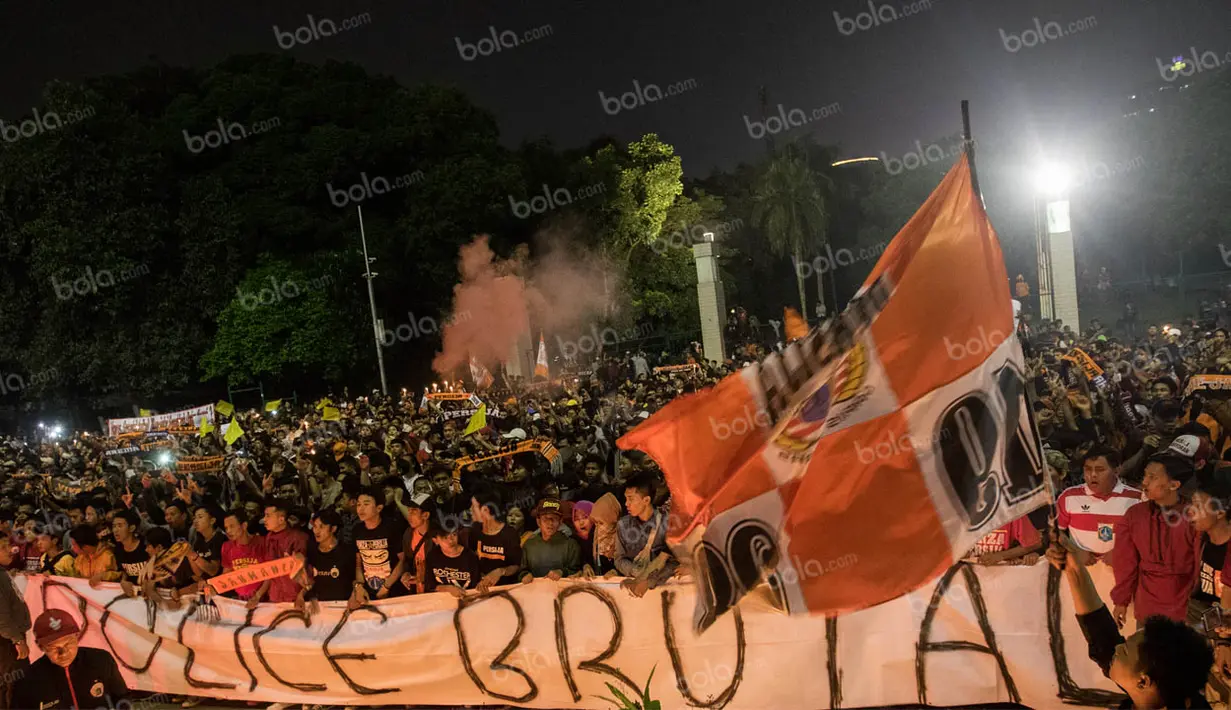Pengurus pusat The Jakmania menggelar aksi tabur bunga tepat di depan pintu masuk yang terakhir kali Reza mengalami kekerasan. Ribuan The Jakmania berkumpul di sektor 12 dengan membawa spanduk, lilin, dan bunga. (Bolaa.com/Vitalis Yogi Trisna)
