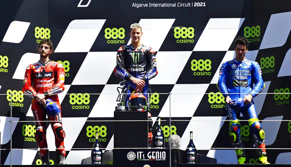 Pembalap Fabio Quartararo (tengah), Francesco Bagnaia (kiri), dan Joan Mir (kanan) berdiri di podium pada pertandingan balap MotoGP Portugal di Sirkuit Algarve International dekat Portimao, Portugal, Minggu (18/4/2021). Fabio Quartararo keluar sebagai juara. (AP Photo/Jose Breton)