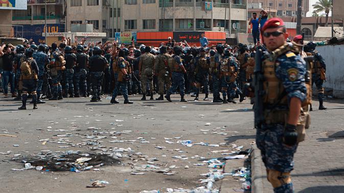 Pasukan keamanan Irak mencegah demonstran antipemerintah menuju Tahrir Square di pusat Baghdad, Irak, Rabu (2/10/2019). Pasukan keamanan dan polisi antihuru-hara dikerahkan untuk menghalangi semua jalan menuju Tahrir Square. (AP Photo/Khalid Mohammed)