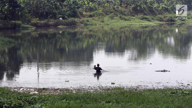 Warga beraktivitas di Situ Pengarengan Kota Depok, Jawa Barat, Kamis (18/4). Tumpukan sampah dan tanaman eceng gondok terlihat menumpuk menutupi permukan air Situ Pengarengan. (Liputan6.com/Helmi Fithriansyah)