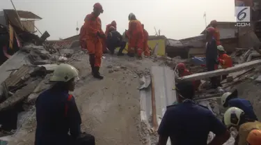 Sejumlah warga menyaksikan evakuasi korban rumah roboh di  Jalan Pulo, Tanah Tinggi, Johar Baru, Jakarta Pusa, Jumat (26/4). Enam orang masih terjebak dan tengah dalam proses evakuasi. (merdeka.com/Imam Buhori)