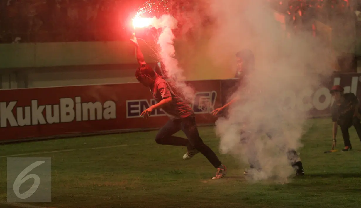 Suporter Persija membakar kembang api pada pertandingan 8 besar Piala Jendral Sudirman antara Persija vs Semen Padang di Stadion Manahan Solo, Minggu (20/12). Skor akhir 6-5 untuk Persija, namun tetap tak lolos ke babak semifinal. (Boy Harjanto)