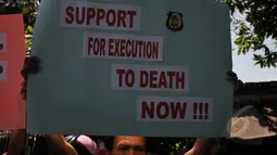 Pegiat Granat membawa poster bertuliskan "Support for Execution to Death Now!!!" saat menggelar aksi  demonstrasi di depan pintu masuk Dermaga Wijaya Pura, Cilacap, Jateng, Jumat (6/3). (Liputan6.com/Johan Tallo)