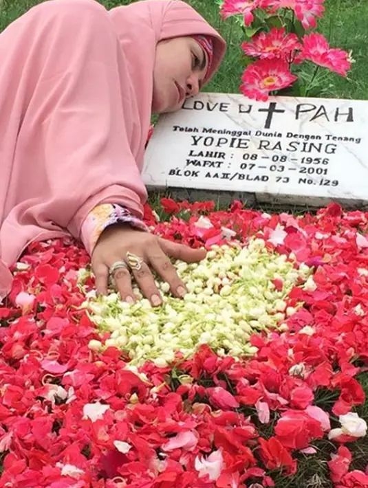 Penyanyi dangdut Cinta Penelope saat nyekar ke makam ayahandanya. Mantan istri Mustafa Debu ini telah menutup auratnya dengan hijab panjang.  (Instagram/princess_cinta_penelope)