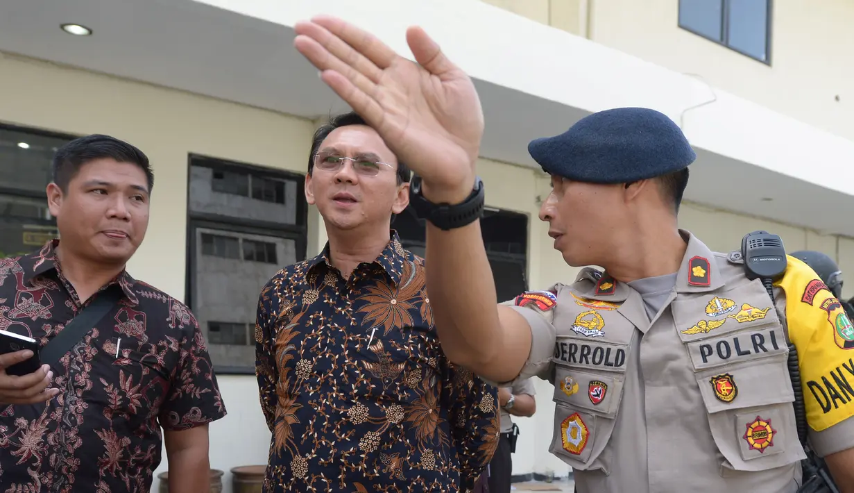 Gubernur DKI Jakarta nonaktif, Basuki Tjahaja Purnama (Ahok) mendengarkan penjelasan seorang polisi terkait rencana meninggalkan PN Jakarta Utara, Selasa (20/12). Sebelumnya Ahok menjalani sidang kedua kasus dugaan penistaan. (REUTERS/Adek BERRY/Pool)