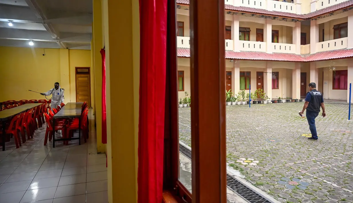 Seorang anggota Badan Penanggulangan Bencana Daerah (BPBD) menyemprotkan disinfektan di dalam ruang makan sebuah Sekolah Menengah Pertama (SMP) dalam rangka program mitigasi pencegahan penyebaran flu burung di Banda Aceh pada Jumat 31 Oktober 2025. Tim dari Badan Penanggulangan Bencana Daerah (BPBD) Kota Banda Aceh melakukan penyemprotan disinfektan ke beberapa sekolah menengah. (Chaideer MAHYUDDIN/AFP)