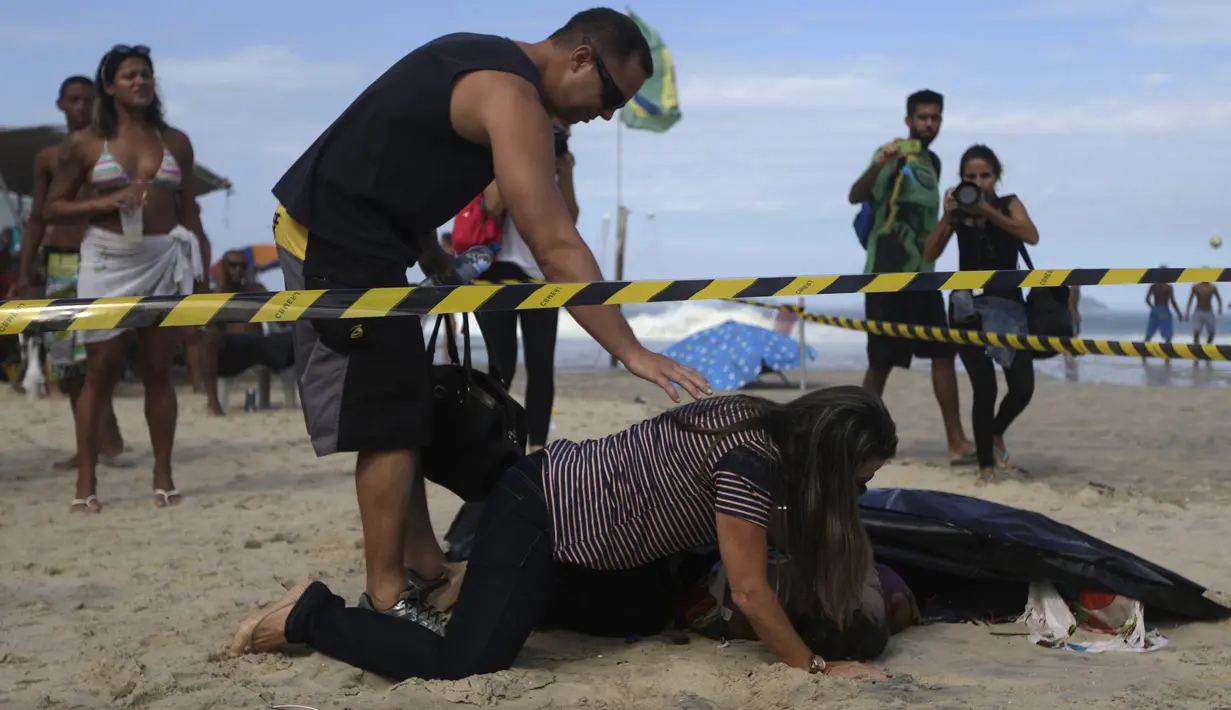 Wanita bernama  Eliane mencium suaminya yang tewas Eduardo Marinho Albuquerque di pantai, Rio de Janeiro , Brasil , 21 April 2016. Dua orang tewas dalam peristiwa runtuhnya bangunan ini. (REUTERS / Ricardo Moraes) 