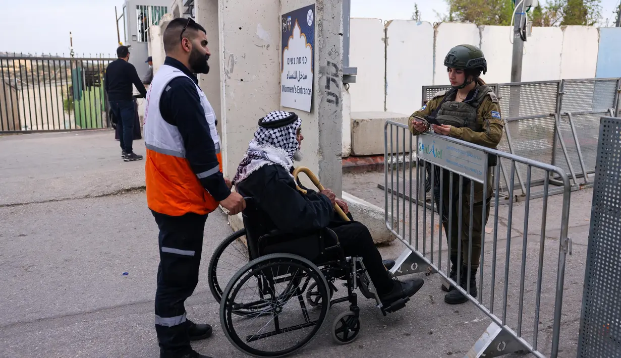Seorang pria Muslim Palestina yang menggunakan kursi roda tiba di pos pemeriksaan Israel di Bethlehem, Tepi Barat yang diduduki Israel, pada 14 Maret 2025. (Hazem BADER/AFP)