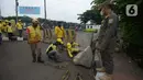 Petugas gabungan memindahkan beton pembatas di Jalur Inspeksi Kanal Banjir Timur (KBT), Cipinang, Jakarta Timur, Kamis (30/12/2021). Kawasan KBT ditutup guna mencegah kerumunan warga yang hendak merayakan malam pergantian tahun. (merdeka.com/Imam Buhori)