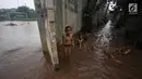 Anak-anak bermain di dekat lapangan di kawasan Kemang, Jakarta, Kamis (16/11). Tingginya intensitas hujan dan pesatnya pembangunan menyebabkan kawasan tersebut langganan banjir yang berasal dari luapan Kali Krukut. (Liputan6.com/Immanuel Antonius)
