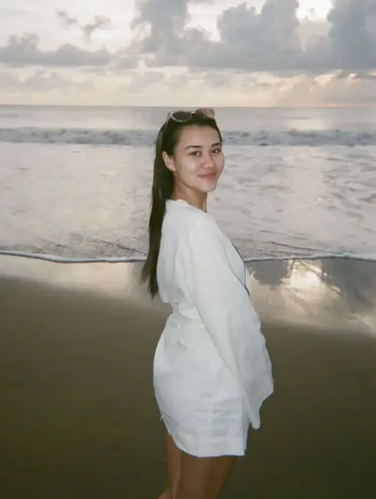 Rambut panjang terurai, Aaliyah pun dibalut dengan mini dress putih saat bermain di pantai.[@aaliya.massaid]