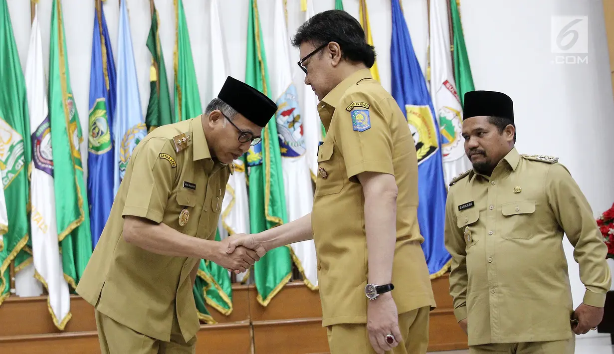 Mendagri, Tjahjo Kumolo (kanan) memberikan selamat kepada Plt Gubernur Aceh Nova Iriansyah usai serah terima surat penugasan Pelaksana Tugas (Plt) Gubernur Aceh dan Bupati Bener Meriah di Kemendagri Jakarta, Senin (9/7). (Liputan6.com/Herman Zakharia)