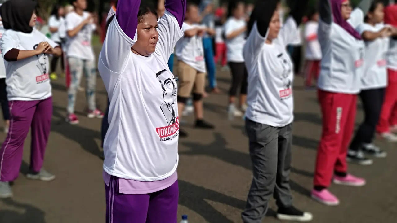 Masyarakat yang mendukung Presiden Jokowi menggelar senam di car free day (CFD), Jakarta