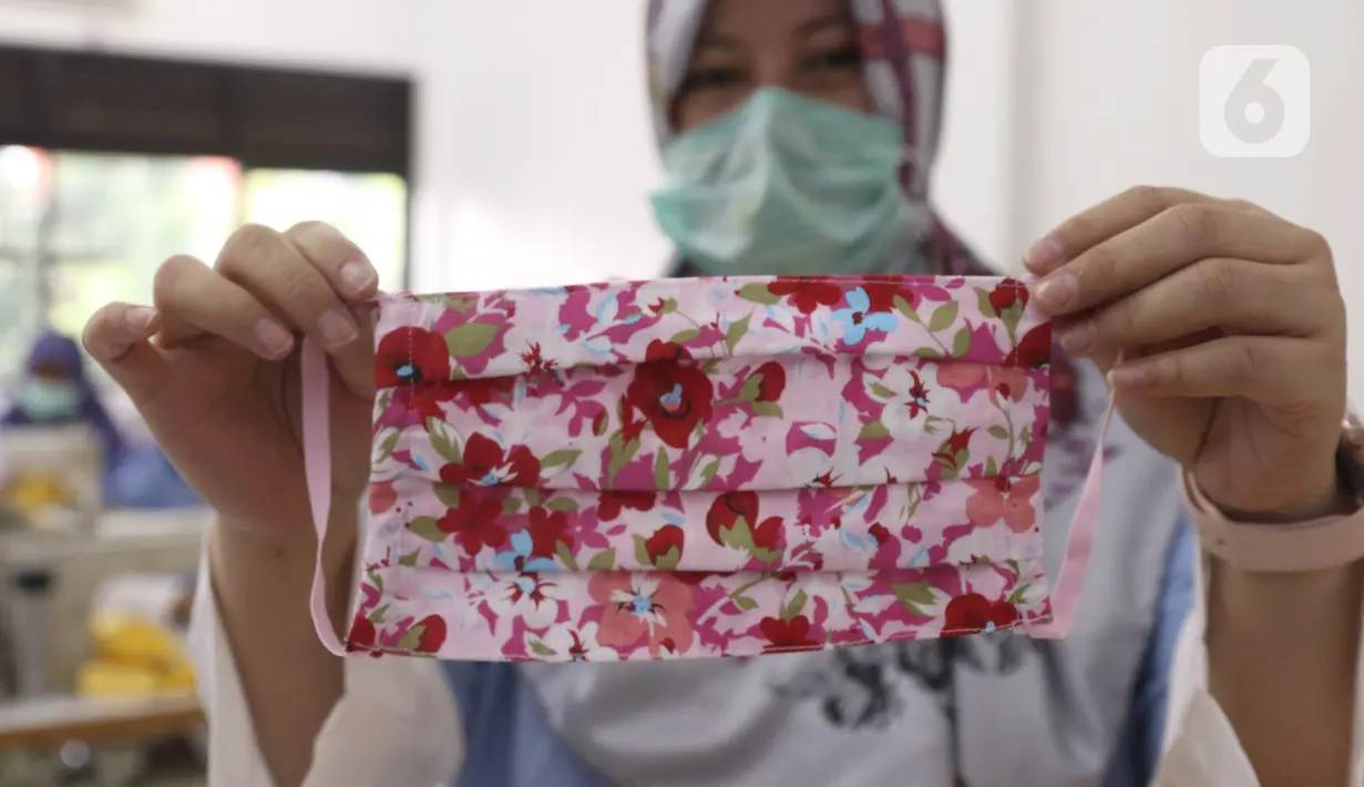 Seorang ibu memperlihatkan masker dari bahan kain yang diproduksi di Balai Latihan Kerja (BLK) Larangan, Tangerang, Senin (6/4/2020). Pemkot Tangerang memproduksi sendiri masker kain untuk didistribusikan ke wilayah Tangerang guna mencegah penyebaran virus corona Covid-19 (Liputan6.com/Angga Yuniar)