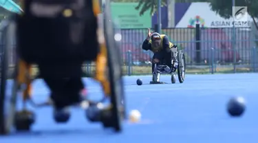 Atlet Para Games Indonesia cabang olahraga Lawn Bowls melakukan lemparan saat latihan di Lapangan Hoki Kompleks GBK, Jakarta, Selasa (18/9). Latihan ini adaptasi lapangan sekaligus persiapan jelang Asian Para Games 2018. (Liputan6.com/Helmi Fithriansyah)