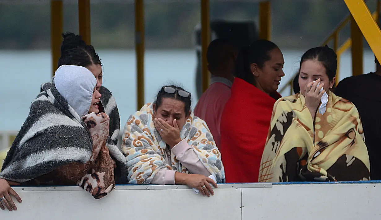 Reaksi korban selamat dari insiden tenggelamnya kapal wisata Almirante di sebuah waduk, Kolombia barat daya, Minggu (25/6). Sesaat setelah kejadian, kapal-kapal wisata di sekitarnya berdatangan memberi pertolongan. (AP Photo/Luis Benavides)