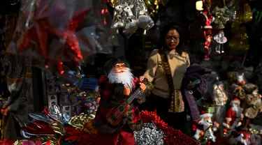 Seorang pelanggan melihat barang-barang dekoratif untuk Natal di sebuah toko di New Delhi pada 18 Desember 2023. (Sajjad HUSSAIN/AFP)
