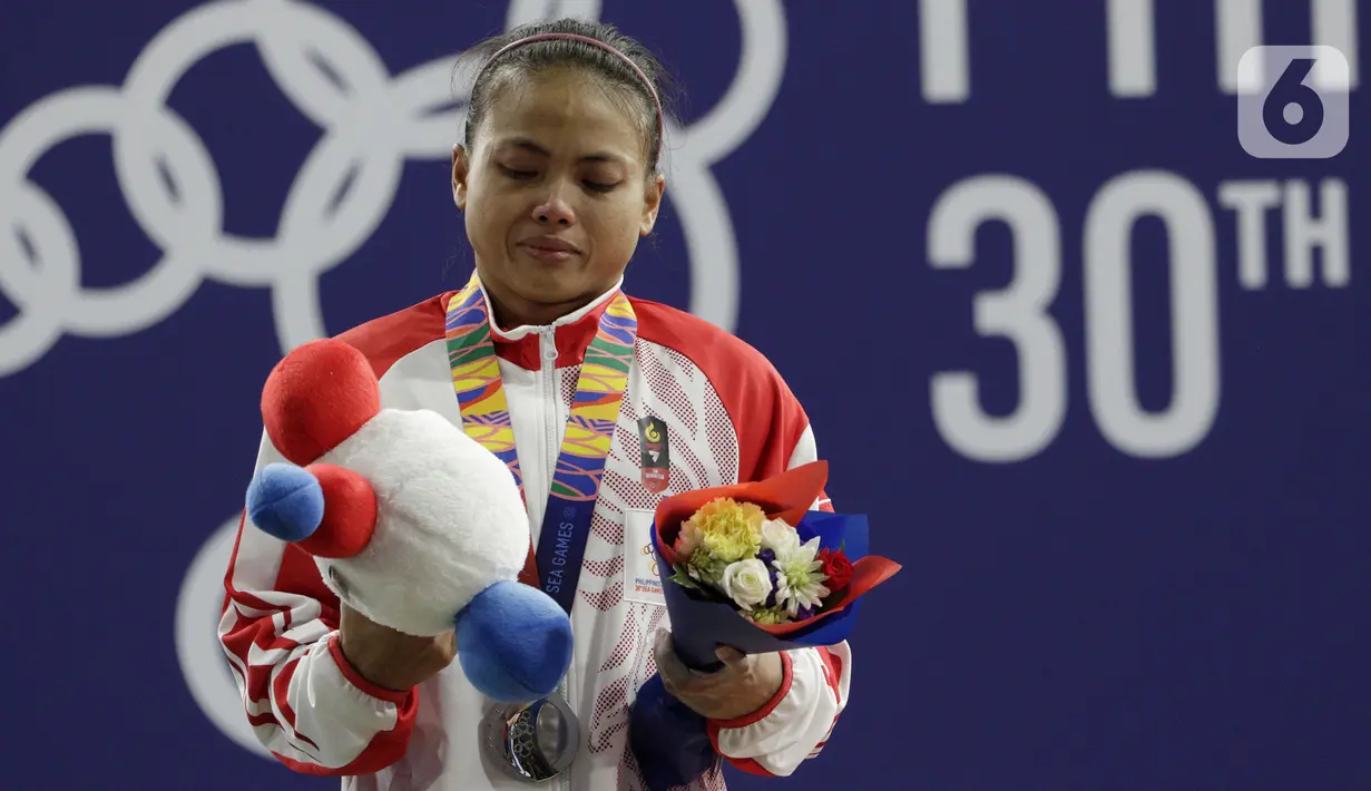 Lifter putri Indonesia, Lisa Setiawati saat naik podium usai mendapatkan medali perak SEA Games 2019 cabang angkat besi nomor 45 kg di Stadion Rizal Memorial, Manila, Minggu (1/12/2019). Dirinya meraih perak dengan total angkatan 169 kg. (Bola.com/M Iqbal Ichsan)