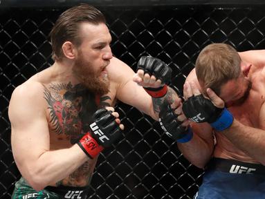 Conor McGregor (kiri) bertarung melawan Donald 'Cowboy' Cerrone pada pertarungan kelas welter UFC 246 di T-Mobile Arena, Las Vegas, Amerika Sertikat, Sabtu (18/1/2020). McGregor mengalahkan Cowboy pada detik ke-40. (AP photo/John Locher)